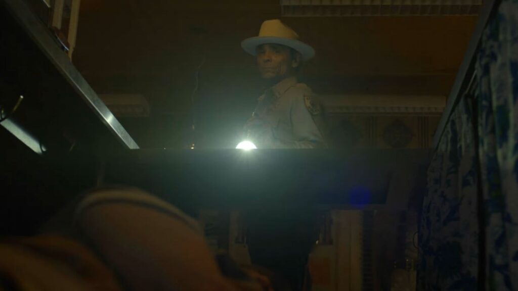 Zahn McClarnon investigates with flashlight in Dark Winds Season 4