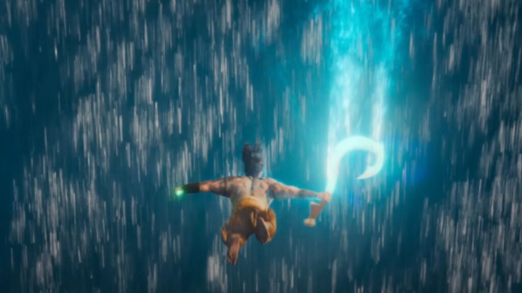 Maui diving through cascading water while holding his glowing hook in Moana Live Action.