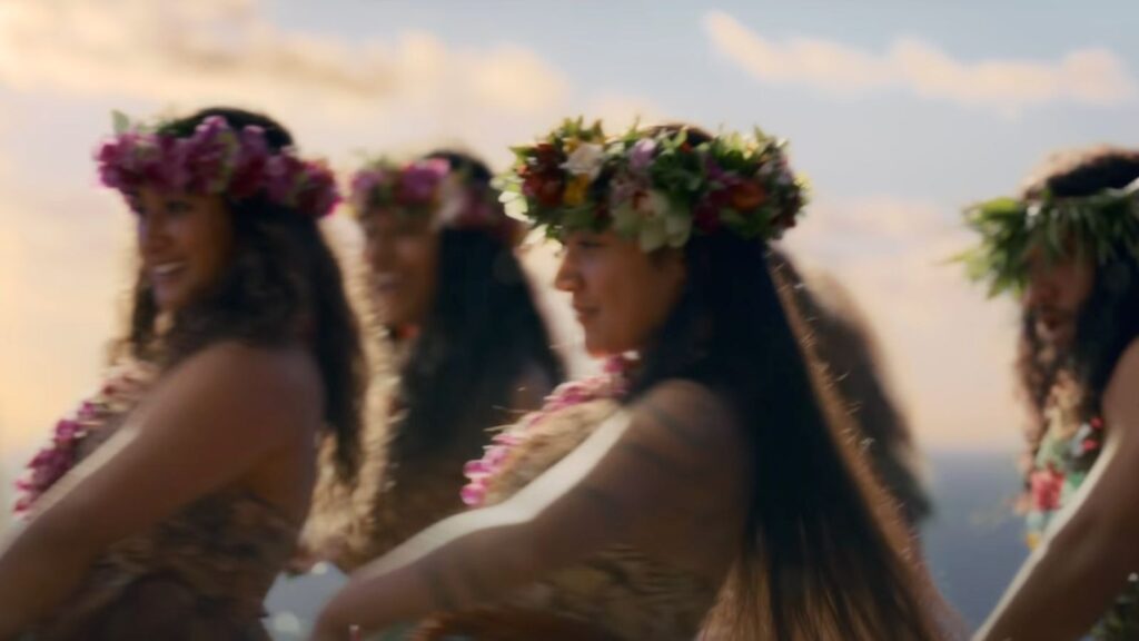 Women of Motunui performing a traditional dance wearing floral crowns and woven garments in Moana Live Action