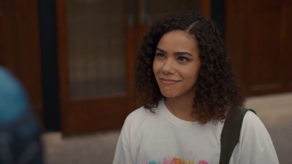 Antonia Gentry smiling during emotional scene in Wellsbury hallway, from Ginny and Georgia season 3