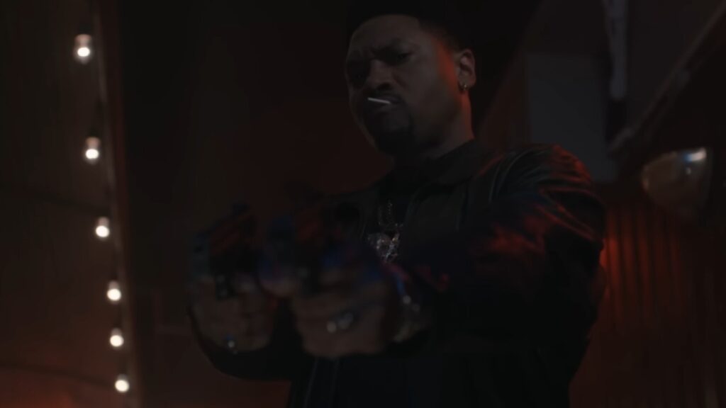 Joey Bada$$ as Unique in Power Book III: Raising Kanan Season 5 aiming guns fiercely