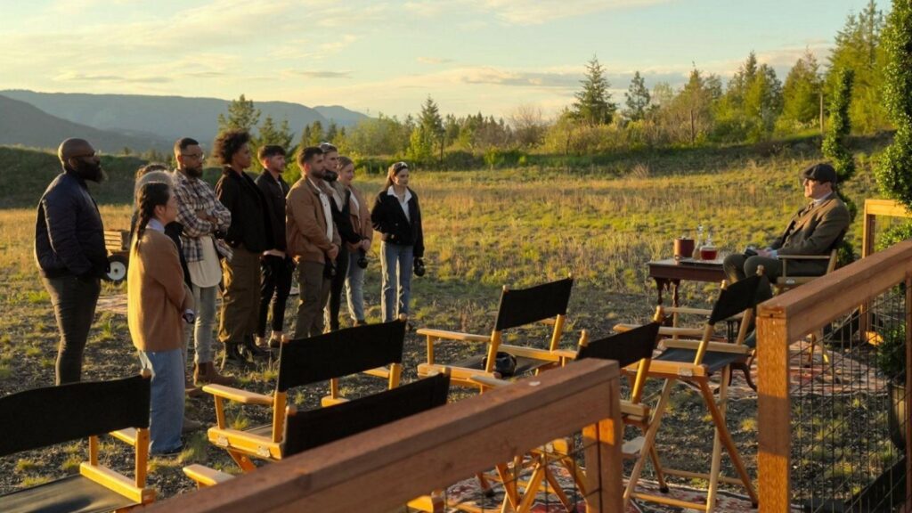 Contestants of Million Dollar Secret standing outdoors facing the seated host in a scenic estate setting.