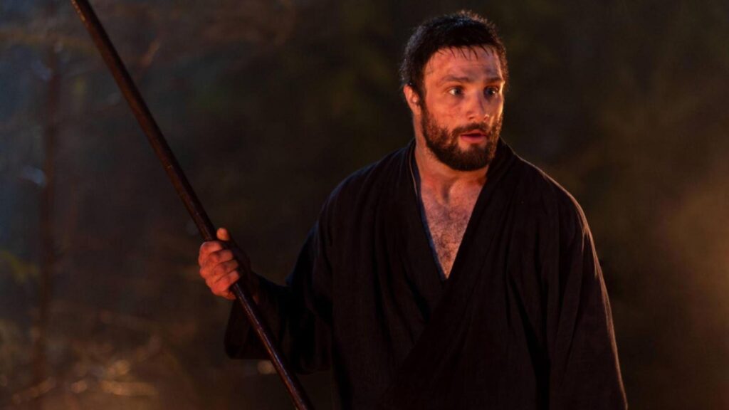 Cosmo Jarvis as John Blackthorne holding spear during intense night scene, from Shogun season 1