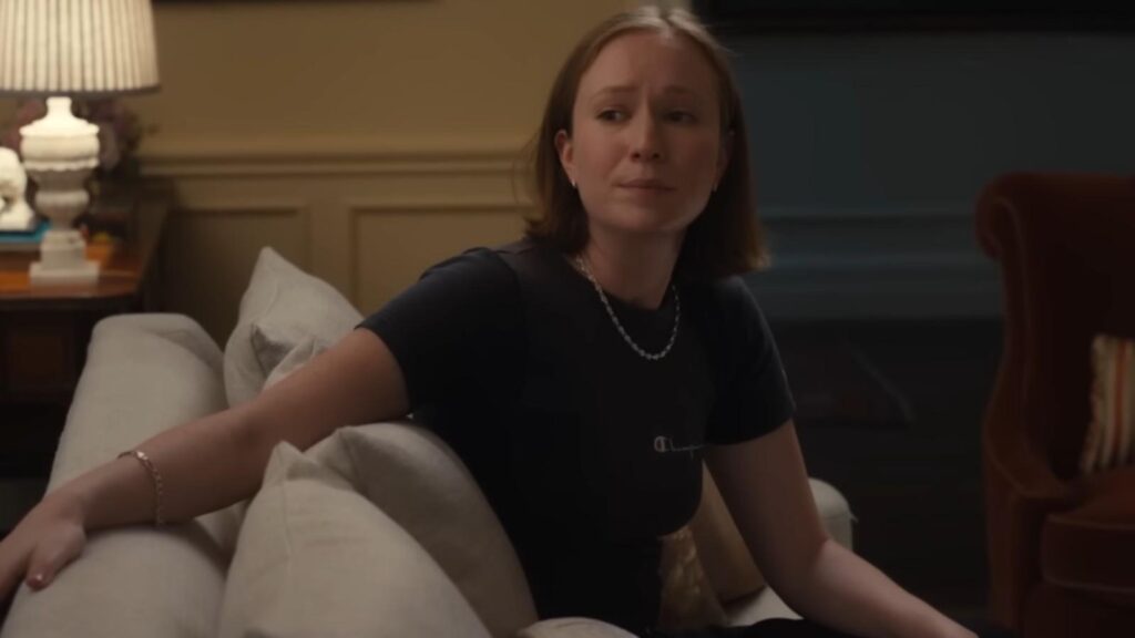 Hannah Einbinder sitting on couch looking concerned in Hacks Season 5