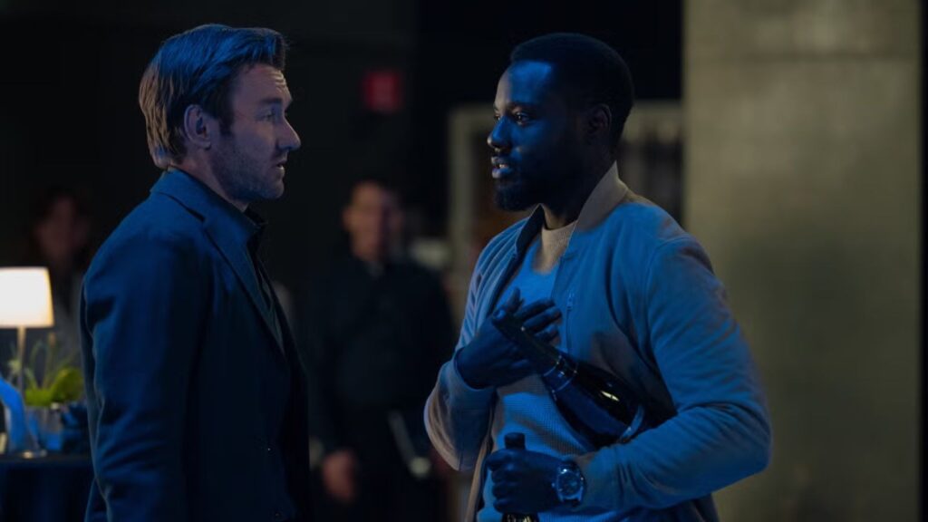 Joel Edgerton speaks with Dayo Okeniyi during tense conversation scene indoors, from Dark Matter season 2