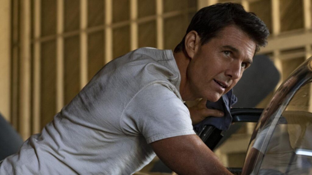 Tom Cruise as Maverick leaning over aircraft preparing for mission scene, from Top Gun Maverick