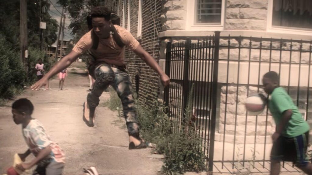 Young man jumps over children during street game, from The Chi season 8