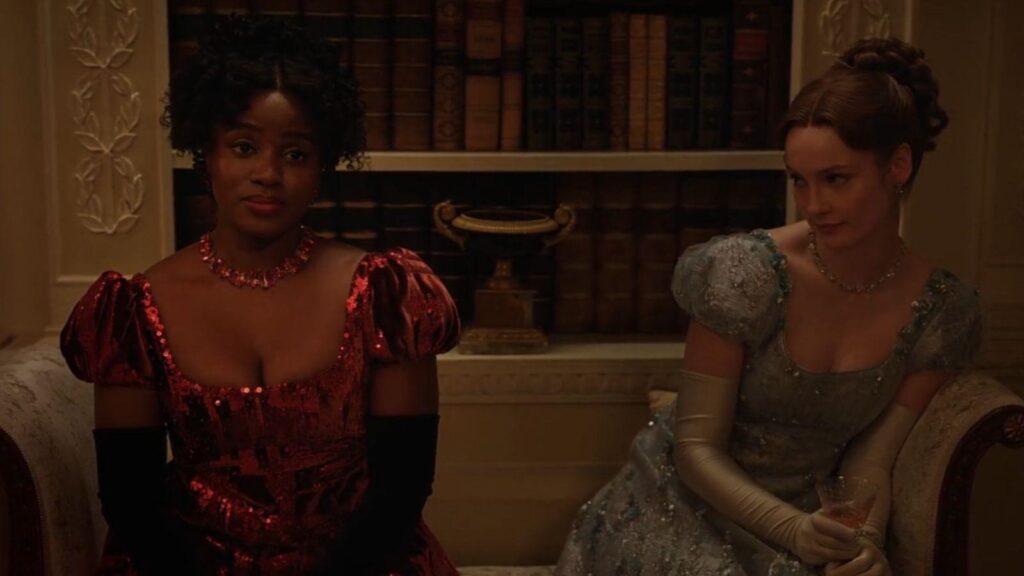 Masali Baduza and Hannah Dodd seated together in ballroom scene, from Bridgerton season 4