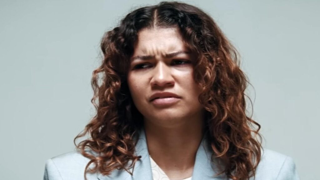 Zendaya looking concerned with furrowed brow wearing blazer in Euphoria Season 3
