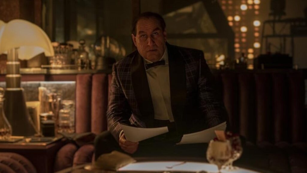 Colin Farrell as Oz Cobblepot in The Batman reviewing documents inside dimly lit lounge