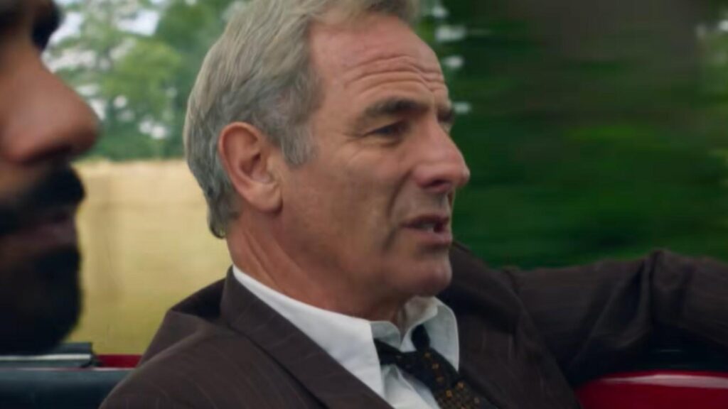 Robson Green as Geordie Keating riding in a red car, from Grantchester Season 11 trailer