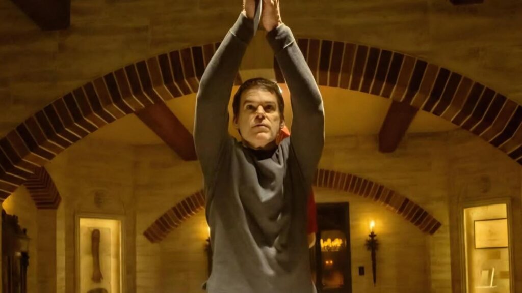Michael C Hall as Dexter Morgan raising arms with blade in ritual stance in Dexter: Resurrection