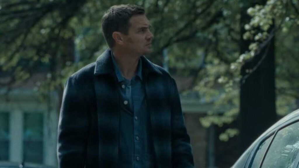 Kyle Chandler as Mitch McLusky standing outdoors looking upward near car in Mayor Of Kingstown Season 4