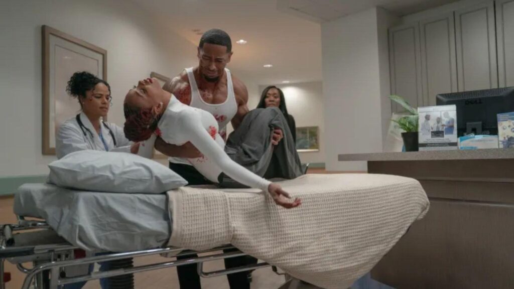  Oshea Russell as Tommy and Racquel Palmer as Blue carried into hospital room, from All The Queen’s Men season 5