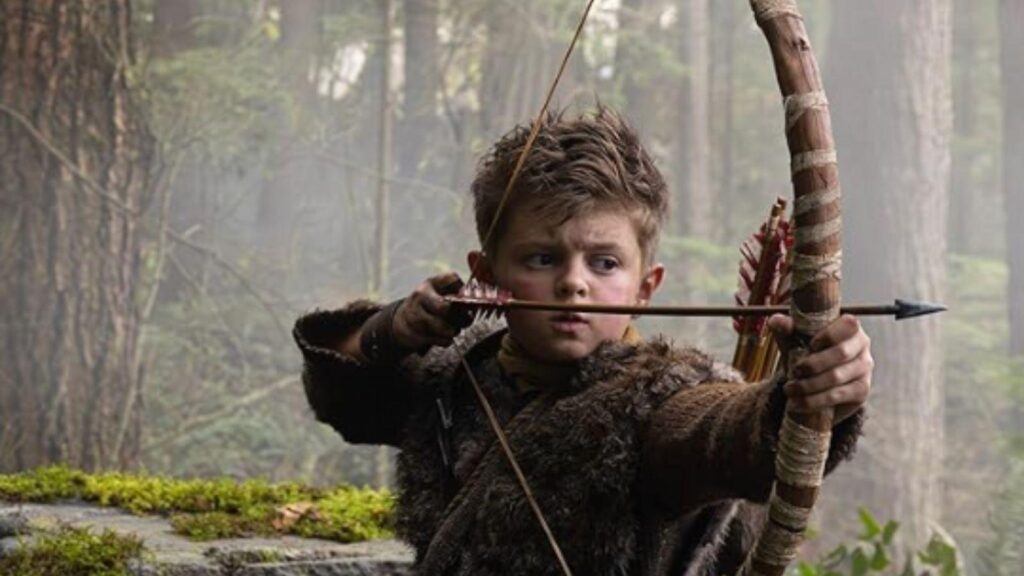 Callum Vinson as Atreus aims bow through forest in God of War series from God of War TV Show