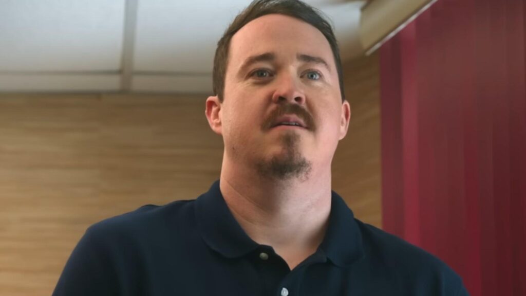 Shane reacting with concerned expression inside tire shop showroom in Tires Season 3