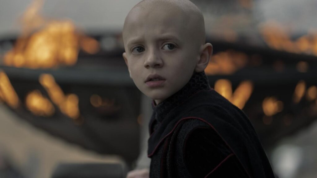 Dexter Sol Ansell as Maester Aemon looking back while flames rage behind in A Knight of the Seven Kingdoms