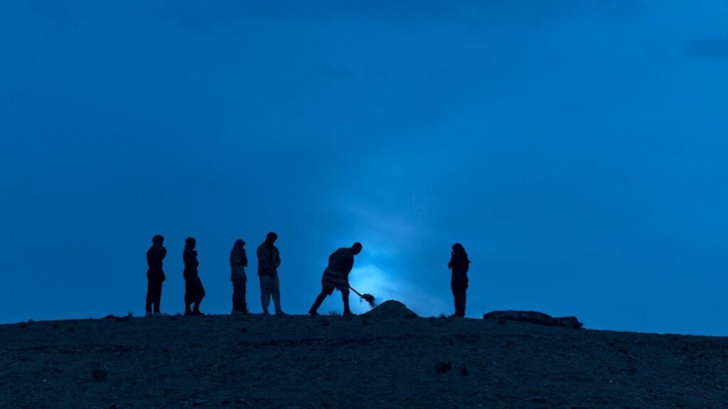 Pouges gathered around a grave at night, from Outer Banks season 5